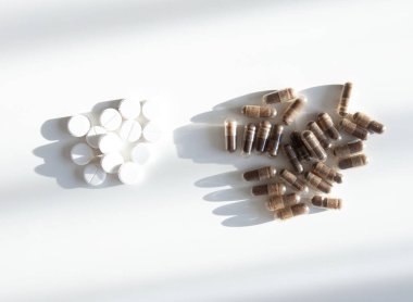 Kapsüller ve tabletler tarafsız yüzeyde. Denge, bağışıklık ve refah kültürünün sembolü.