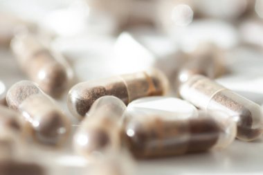 Beyaz bir yüzeye dağılmış renkli vitaminler. Beslenme, denge ve sağlıklı yaşam tarzını sembolize eder.