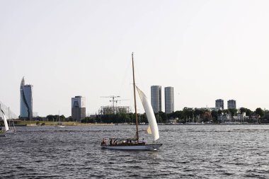 Riga, Letonya - 30 Haziran 2024: Yatlar sabit rüzgarla çalışan dalgaları kesiyor.