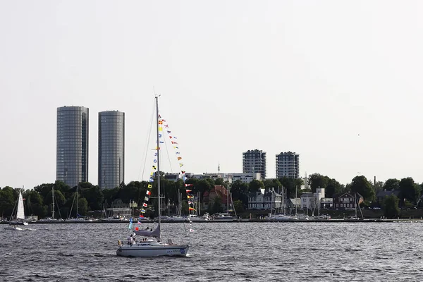 Riga, Letonya - 30 Haziran 2024: Mavi deniz dalgaları üzerinde renkli yelkenler süzülüyor.