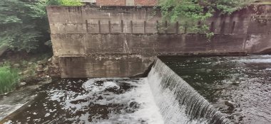 Huzurlu bir su deposu çevredeki yeşillikleri yansıtır..