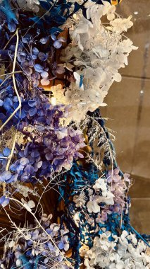 Kurumuş çiçeklerin yumuşak odak bileşimi ve parıldayan ışık çizgileriyle iç tasarım elementi olarak düzenlenmiş süslemeli bitkiler. Kurumuş bitkiler, ortanca yaprakları ve sıcak ışığın sıcacık estetik bir ortam oluşturduğu soyut çiçek arkaplanı.