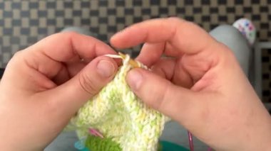 Bambu örgü iğneli yeşil beyaz bir köpek süveteri örme süreci. Üst Manzara. Hobi olarak. El yapımı..