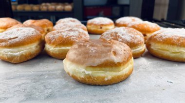 Yumuşak altın hamur, kremalı dolgu ve pudra şekeri. Sığ alan derinliği, zanaat hamur işi konsepti, taze tatlı üretimi..