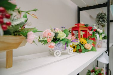 İç dekorasyon için sahte çiçekler. Masadaki tencerede yapay çiçek.