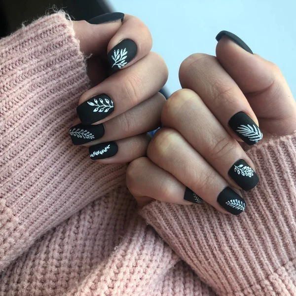 Black manicure. Hands of a woman with black manicure on nails.Manicure beauty salon concept. Empty place for text or logo.