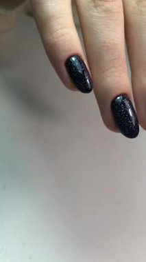 Siyah manikür. Tırnaklarında siyah manikür olan bir kadının elleri. Manikür güzellik salonu konsepti. Metin veya logo için boş yer.