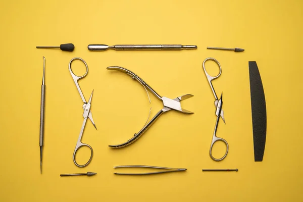 Set of manicure tools and accessories on a yellow background,flat lay.Top view of manicure and pedicure equipment on yellow background