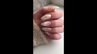 Tırnaklarında pembe manikür olan bir kadının elleri. Manikür güzellik salonu konsepti. Metin veya logo için boş yer.