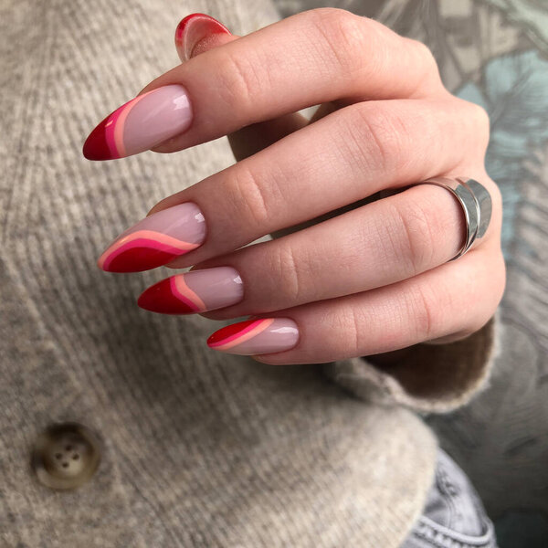 Многоцветный маникюр вблизи. Молодая женщина руки с пастельным маникюром. Яркий разноцветный дизайн маникюра