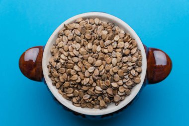 Mavi arka planda kil kapta karpuz tohumları. Karpuz tohumları arka planda.