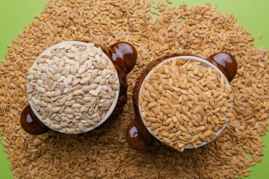 Yeşil arka planda kil kapta kavun çekirdekleri. Karpuz arka planda.