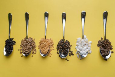 Sarı arka planda karpuz, balkabağı ve kavun tohumları. Farklı tohum türleri, üst görünüm. Tohumlar.