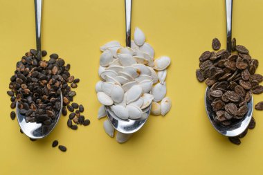 Sarı arka planda karpuz, balkabağı ve kavun tohumları. Farklı tohum türleri, üst görünüm. Tohumlar.