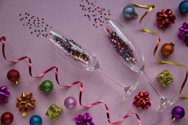 Gözlüklerin yaratıcı Noel düzeni ve pembe arka planda yeni yıl süslemeleri. Tebrik kartı. Kış tatili, Noel zamanı konsepti. Düz yatıyordu.