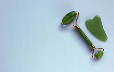 Jade Face Roller ve Gua sha Stone güzellik masajı terapisi için. Cilt Bakımı Yaşlanma Karşıtı Aracı. Doğal bütünsel güzellik kavramı. Düz yat, boşluğu kopyala.