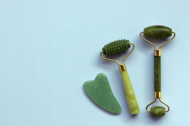 Yüz masajı terapisi için iki yeşim taşı ve Gua sha taşı. Evde reşit olmama, kaldırma ve tonlama tedavisi. Benlik ve güzellik anlayışı. Düz yat, boşluğu kopyala.
