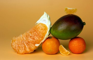 Mandalina, mango, sarı arkaplandaki pomelo dilimi. Dengeli gıda dengesi. Boşluk kağıt kartını kopyala.