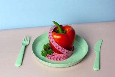 Pembe ve mavi arka planda şeritli biberli ve maydanozlu yaratıcı düz kompozisyon. Aralıklı, keto, detoks ve ince diyetler. Sağlıklı beslenme konsepti. Boşluğu kopyala.