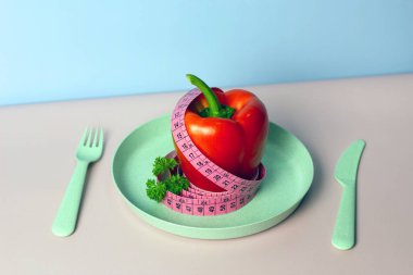 Pembe ve mavi arka planda şeritli biberli ve maydanozlu yaratıcı düz kompozisyon. Aralıklı, keto, detoks ve ince diyetler. Sağlıklı beslenme konsepti. Boşluğu kopyala.