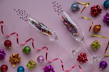 Gözlüklerin yaratıcı Noel düzeni ve pembe arka planda yeni yıl süslemeleri. Tebrik kartı. Kış tatili, Noel zamanı konsepti. Düz yatıyordu.