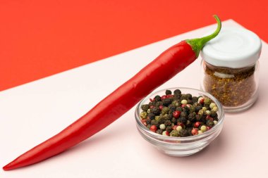 Pembe ve kırmızı arka planda taze biber ve aromalı baharatlar. Yaratıcı minimalizm kavramı. Boşluğu kopyala.