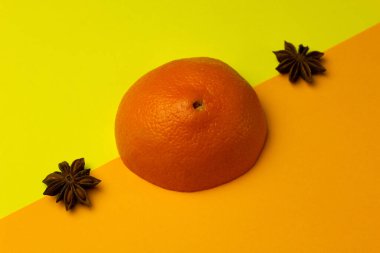 Parlak bir arka planda turuncu ve anason yıldızlarının modaya uygun yerleşimi. Meyve aromalı kombinasyon kavramı. Yaratıcı minimalizm kavramı. Boşluğu kopyala.