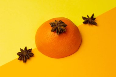 Parlak bir arka planda turuncu ve anason yıldızlarının modaya uygun yerleşimi. Meyve aromalı kombinasyon kavramı. Yaratıcı minimalizm kavramı. Boşluğu kopyala.