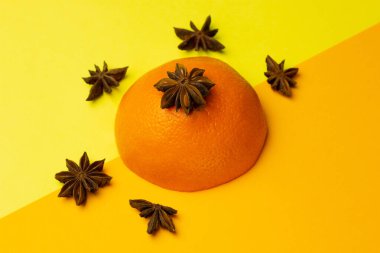 Parlak arka planda turuncu ve anason yıldızlı yaratıcı düz kompozisyon. Meyve aromalı karışım. Minimalizm kavramı. Boşluğu kopyala.