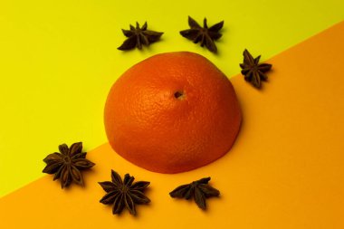 Parlak arka planda turuncu ve anason yıldızlı yaratıcı düz kompozisyon. Meyve aromalı karışım. Minimalizm kavramı. Boşluğu kopyala.
