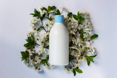 Kozmetik, saç ve cilt bakım ürünleri ve çiçek açan bahar ağaçları içeren plastik şişenin moda bileşimi. Doğal organik kozmetik konsepti. Kopyalama alanı olan ürün modeli.