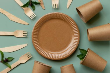 Çevre dostu, kraft, tek kullanımlık, geri dönüşüm gereçleri. Yeşil arka planda yemek için kağıt tabaklar. Sürdürülebilir yaşam tarzı konsepti. Sıfır kayıp. Boşluğu kopyala.
