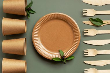 Çevre dostu, kraft, tek kullanımlık, geri dönüşüm gereçleri. Yeşil arka planda yemek için kağıt tabaklar. Sürdürülebilir yaşam tarzı konsepti. Sıfır kayıp. Boşluğu kopyala. 
