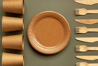 Çevre dostu, kraft, tek kullanımlık, geri dönüşüm gereçleri. Yeşil arka planda yemek için kağıt tabaklar. Sürdürülebilir yaşam tarzı konsepti. Sıfır kayıp. Boşluğu kopyala.
