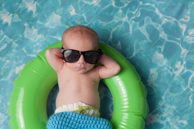 Newborn Baby Boy Floating on an Inflatable Swim Ring clipart