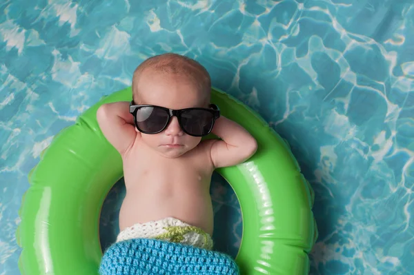 Neugeborener Junge schwimmt auf aufblasbarem Schwimmring — Stockfoto