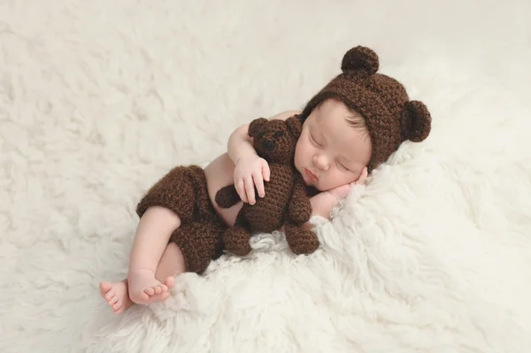 Menino recém-nascido com chapéu de urso e brinquedo — Fotografia de Stock