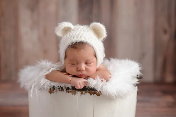 Nyfödd flicka klädd i en vit Björn hatt — Stockfoto
