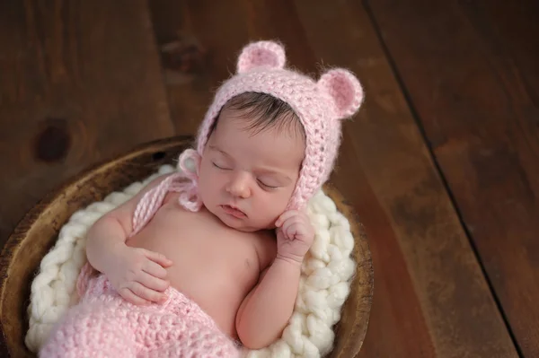 Neugeborenes Mädchen mit rosa Bärenhut — Stockfoto