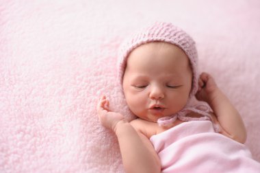 Bir pembe, örme şapka takınca yeni doğan bebek kız