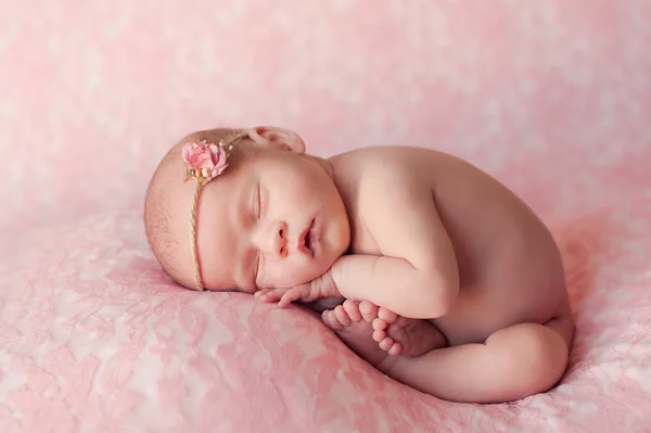 Sovande nyfödd baby flicka på rosa — Stockfoto