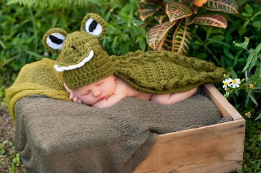 Yeni doğan bebek bir timsah giyinen