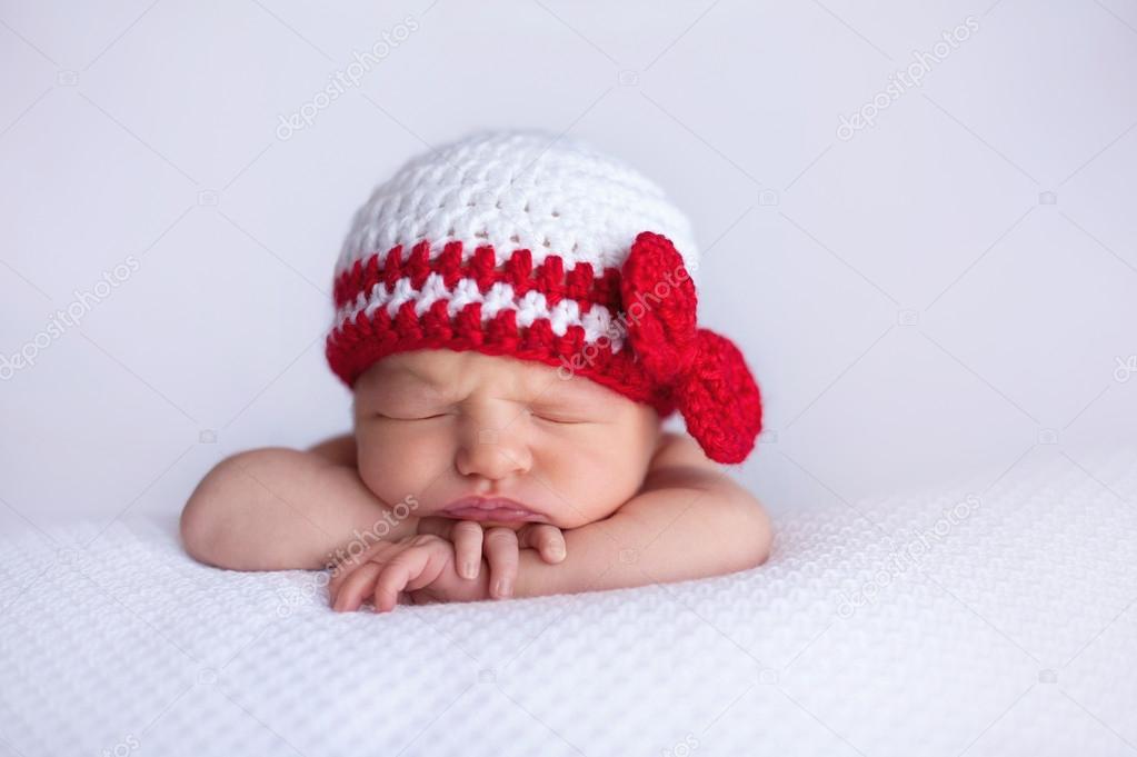 Newborn Baby Girl Wearing a White and Red Crocheted Cap