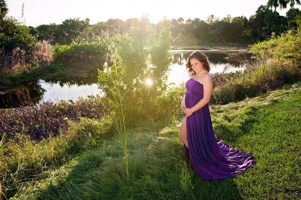 Retrato de maternidade de uma mulher perto da borda de um lago — Fotografia de Stock