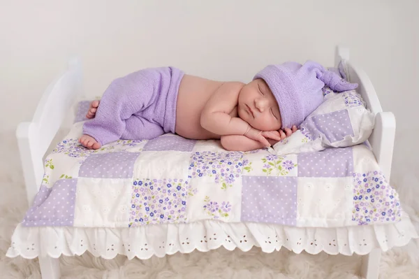 Bebê menina dormindo em uma pequena cama — Fotografia de Stock