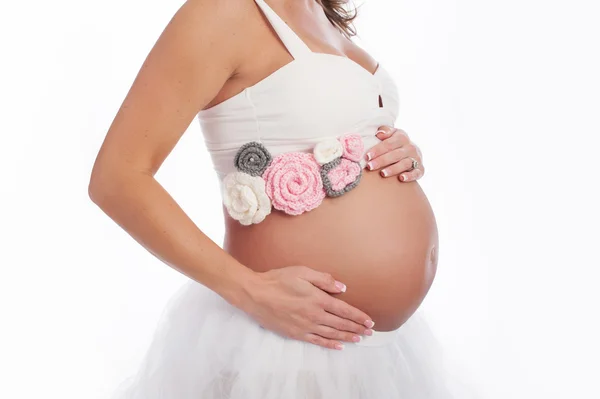 孕妇的肚子，有粉红色的钩针编织腰带 — 图库照片