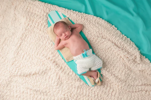 Újszülött fiú alszik egy szörfdeszka — Stock Fotó