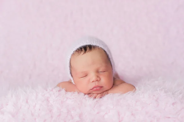 Nyfödd Baby flicka klädd i en rosa stickad Bonnet — Stockfoto