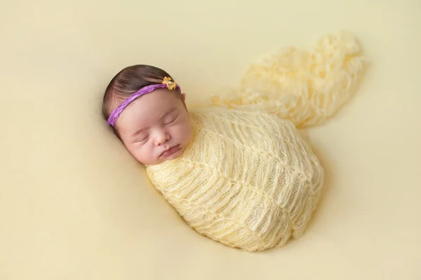 黄色で Swaddled 睡眠の生まれたばかりの赤ちゃん女の子 — ストック写真