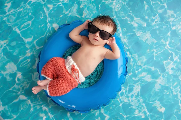 Menino recém-nascido flutuando em um tubo interno — Fotografia de Stock